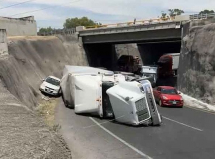 Vuelca tráiler y golpea a auto 