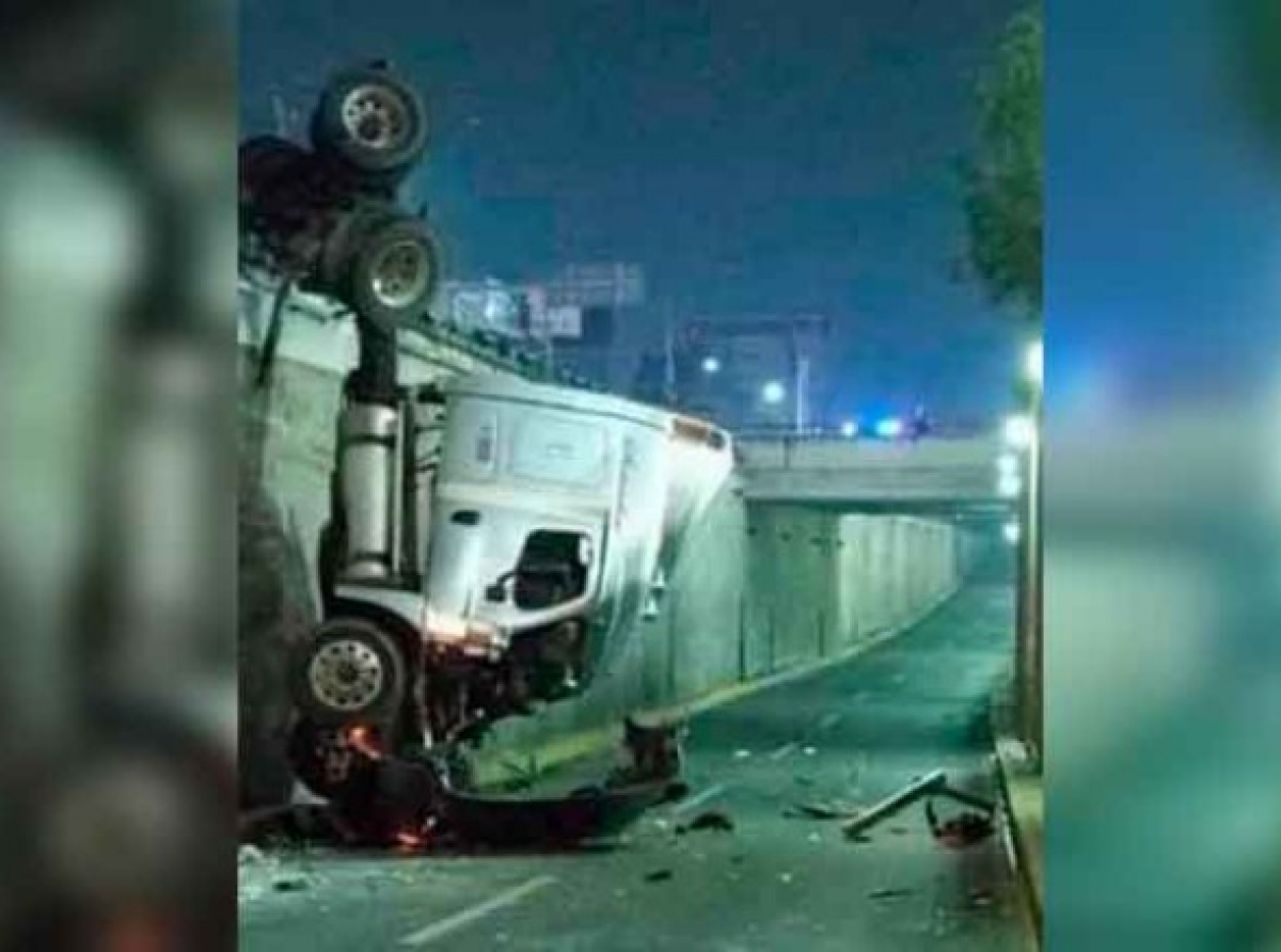  Aparatosa volcadura; tráiler queda colgado de puente 