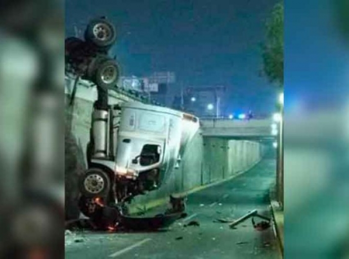  Aparatosa volcadura; tráiler queda colgado de puente 