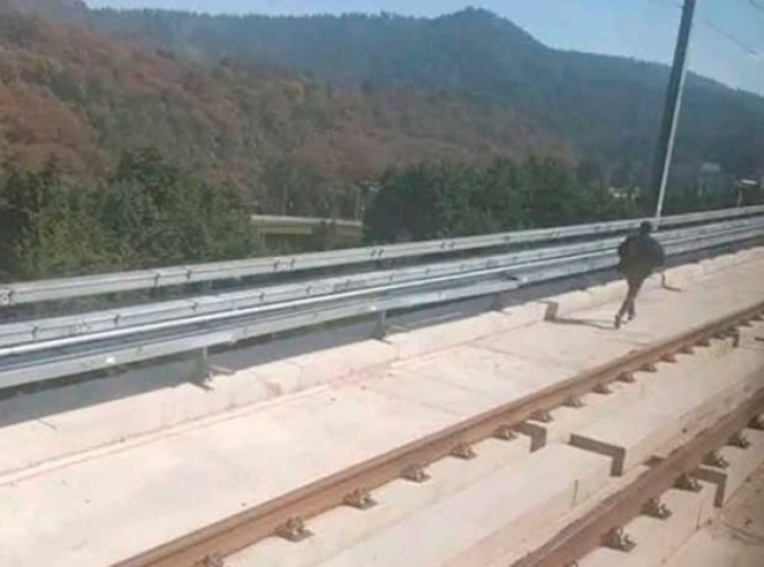 Hombre camina sobre las vías del Tren Interurbano